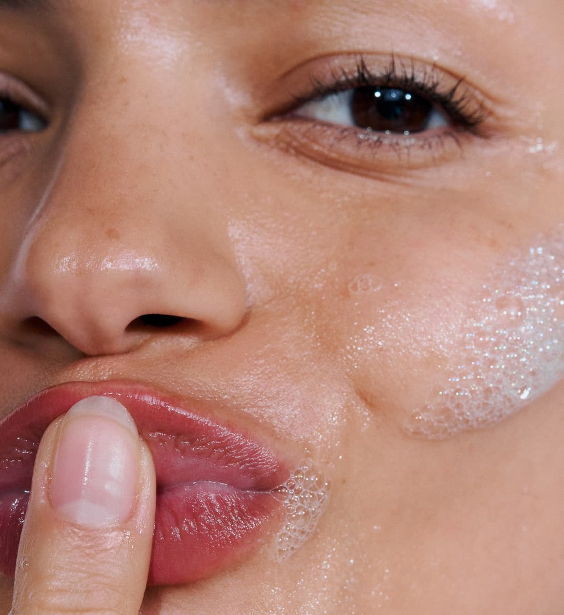 close up of a model's face with bubbles on her face