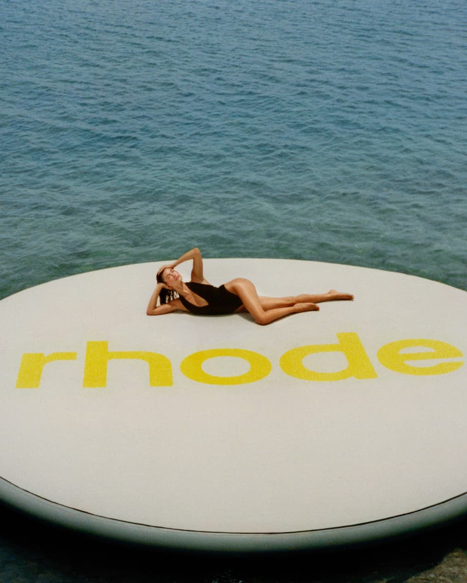 HB lying down on a giant float with rhode logo